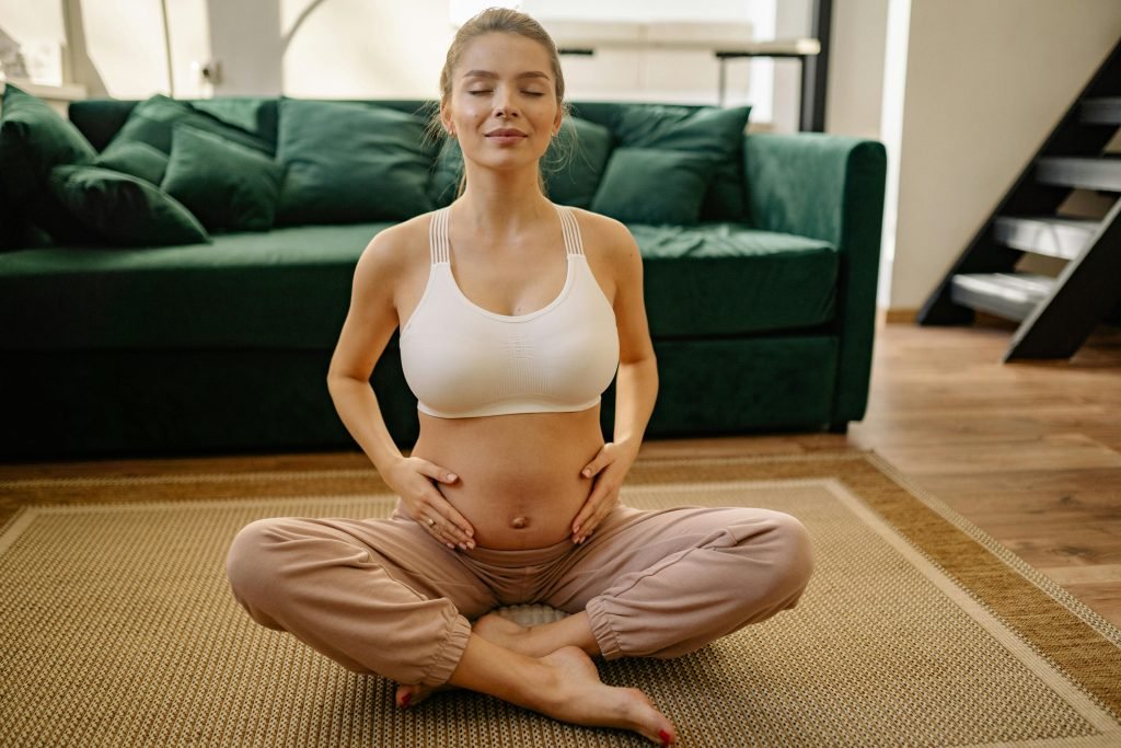 Expectant mother practicing meditation at home for healthy living.